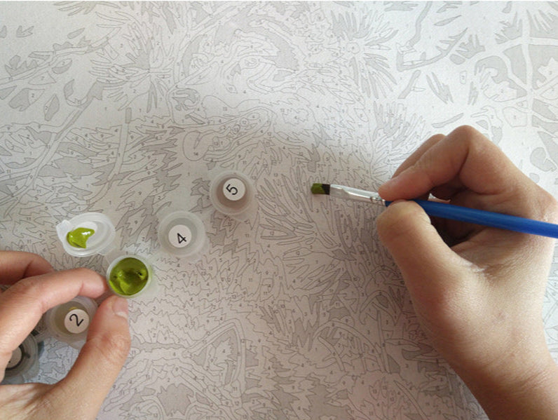 Paint by numbers tools in use 2 hands painting