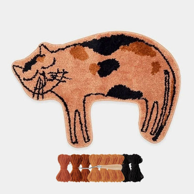 Cat-shaped rug with embroidery floss and a needle on a light gray background