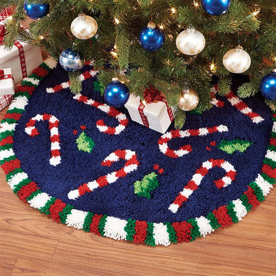 Decorative Christmas tree skirt with candy cane design on a wooden floor.