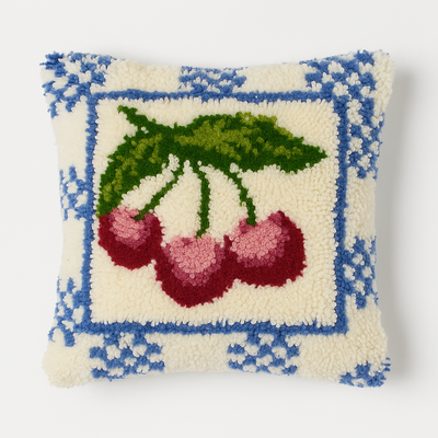 Decorative pillow with cherry design on a white background