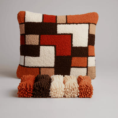 Decorative pillow with geometric pattern and tassels on a plain background