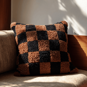 Checkered pillow on a sofa with warm lighting