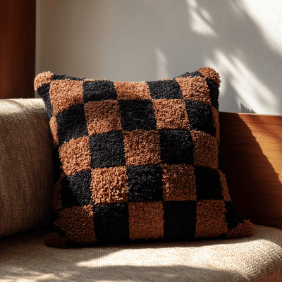 Checkered pillow on a sofa with warm lighting