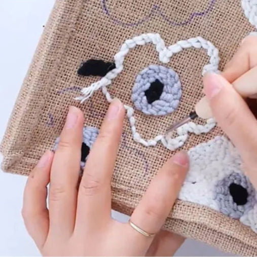 Handcrafting a decorative design on fabric with a punch needle.
